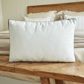 Almohada blanca con ribete gris sobre banco de madera en dormitorio-gris