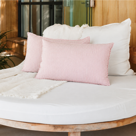 almohadon tusor de raya fina sobre sillón de estar-rosa