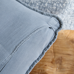 
                    
                      Detalle de funda de almohada gris con ribete y costura visible-
                    
                  