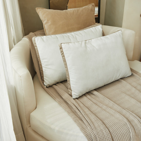 Almohada beige Londres con ribete en cómodo sofá crema-beige