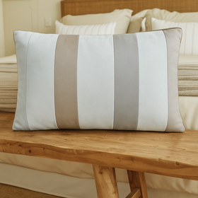 Almohada decorativa con rayas verticales beige y blanco en cama de madera-