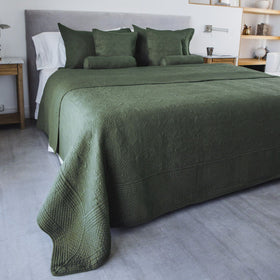 Cubrecama verde Amalfi en cama con almohadas y decoración minimalista-verde