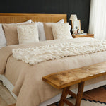 
                    
                      Cama con funda de edredón beige y almohadas decorativas de lino-
                    
                  