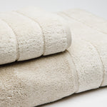 
                    
                      Set de toallas beige apiladas mostrando textura suave y bordes-beige
                    
                  