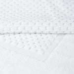 
                    
                      Textura de toalla blanca con patrón punteado y costura visible-
                    
                  
