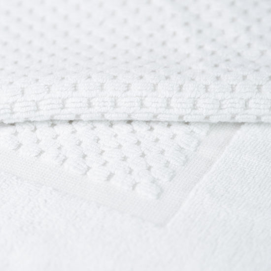 Textura de toalla blanca con patrón punteado y costura visible-