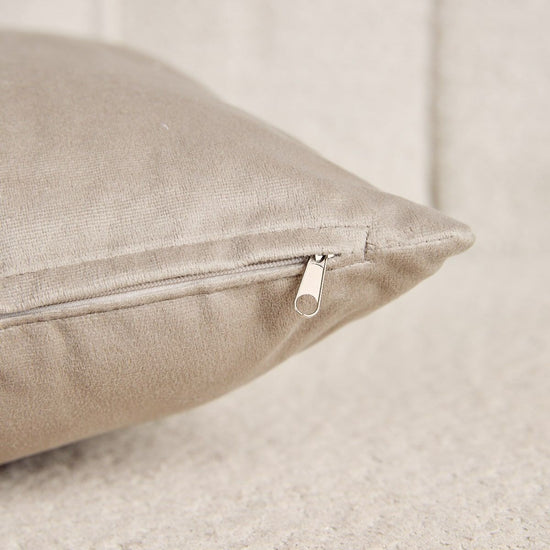 Almohada de lino beige con cremallera plateada y fondo neutro-