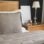 
                    
                      Funda almohada Basic beige con botones decorativos en cama-
                    
                  
