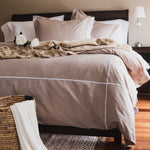 
                    
                      Cama elegante con funda edredón beige, almohadas y flores blancas decorativas-beige
                    
                  