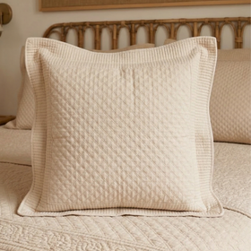 Funda de almohón Berna beige con diseño acolchado en cama-beige