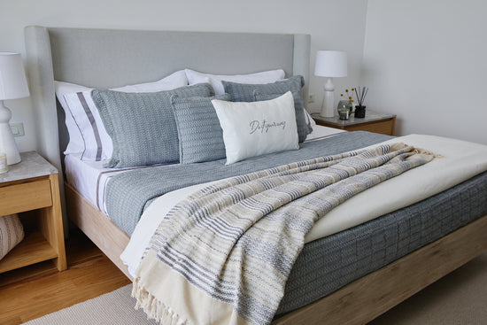 Cubrecama Bradford gris sobre cama con almohadas decorativas a juego-gris