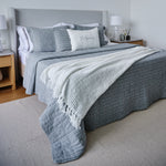 
                    
                      Cubrecama Bradford gris sobre cama con almohadas y lámpara nocturna-gris
                    
                  