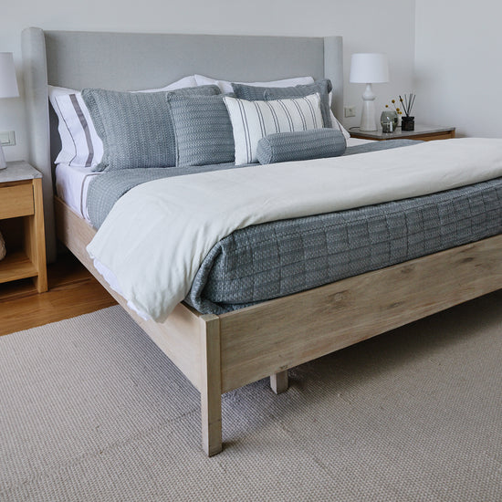 Cubrecama gris Bradford sobre cama con almohadas decorativas a juego-gris