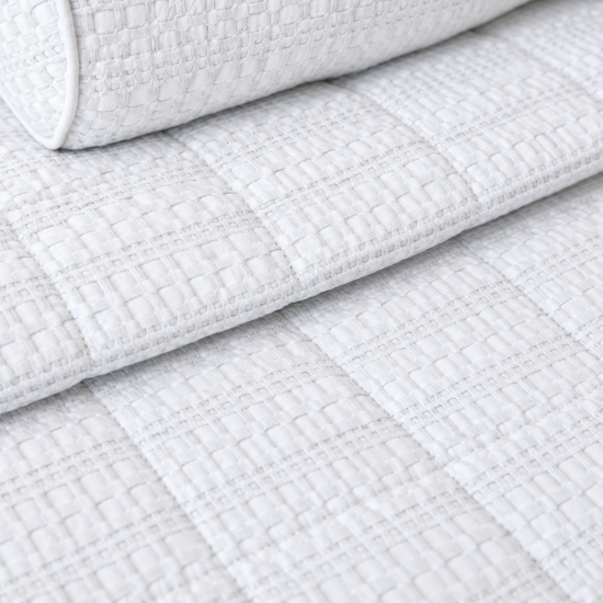 Cubrecama blanco Bradford sobre cama con almohadas decorativas a juego-blanco