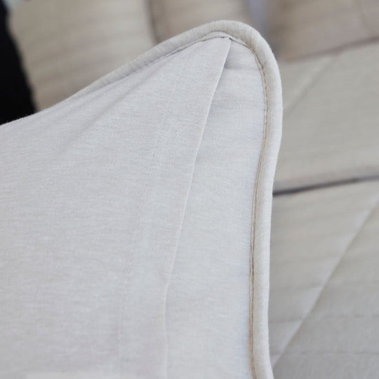 Detalle de funda de almohada beige con costura y acabado de borde-beige