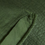 
                    
                      Detalle de tela verde texturizada con costuras y pliegues naturales-verde
                    
                  