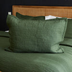 
                    
                      Funda de almohada Girona Traditional en color verde sobre cama con cabecero de madera-verde
                    
                  