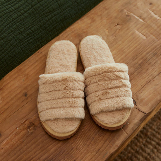 Pantuflas Clara beige con diseño de rayas acolchadas sobre piso de madera-beige