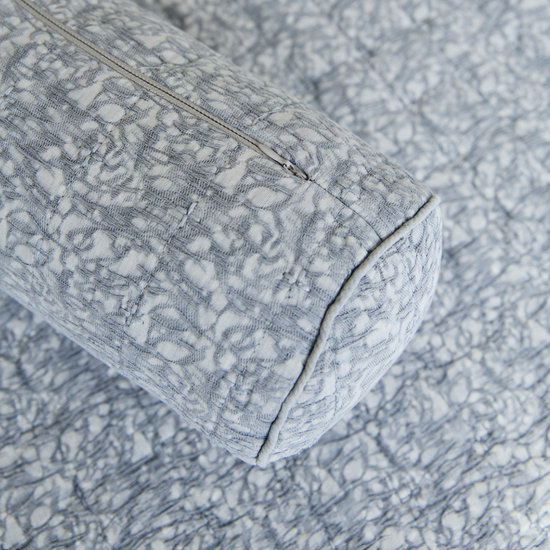 Detalle de sofá gris con patrón textil y costura visible-gris