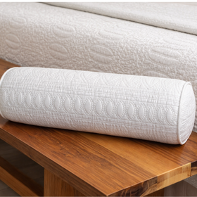 Almohada cilíndrica blanca acolchada sobre mueble de madera-blanco