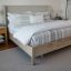 
                    
                      Cubrecama gris y blanco de rayas en cama de madera clara-
                    
                  