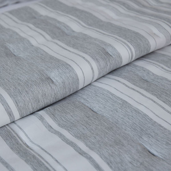 Cubrecama gris y blanco con rayas texturizadas y diseño moderno-