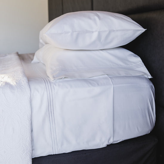 Juego de sábanas blancas de algodón egipcio con festones en cama-blanco