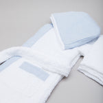 
                    
                      Bata de baño infantil celeste con toalla y accesorios de baño blancos-celeste
                    
                  