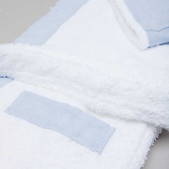 Bata de baño infantil celeste con etiqueta y textura suave-celeste