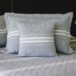 
                    
                      Almohada gris con rayas blancas decorativas sobre cama-gris
                    
                  