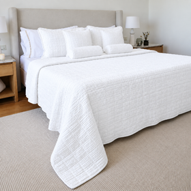 Cubrecama blanco Bradford sobre cama con almohadas decorativas a juego-blanco
