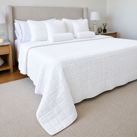 Cubrecama blanco Bradford sobre cama con almohadas decorativas a juego-blanco