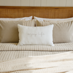 
                    
                      Cama con funda edredón beige y almohada blanca con texto enjoy life-beige
                    
                  