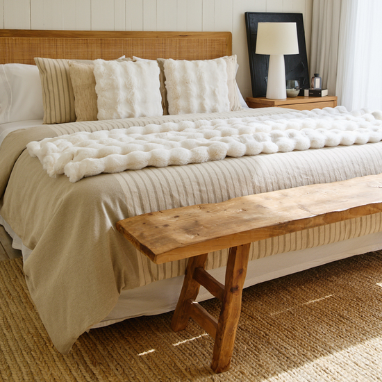 Cama elegante con funda edredón beige y almohadas decorativas blancas-beige