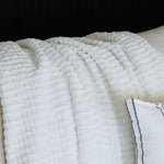 
                    
                      Manta Venecia blanco con textura acanalada y ribete azul marino-blanco
                    
                  
