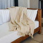 
                    
                      Manta beige con flecos sobre cama de madera con almohadas-natural
                    
                  
