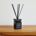 
                    
                      Difusor de varitas negras con base cúbica negra sobre mesa de madera-arrayán
                    
                  
