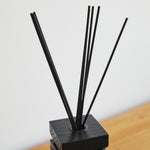 
                    
                      Difusor de aromas con varillas negras en base de madera cuadrada-
                    
                  