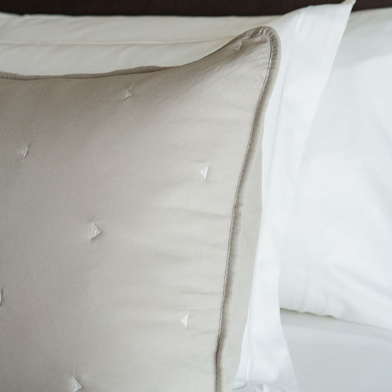 Funda almohada beige con detalles triangulares blancos decorativos-natural