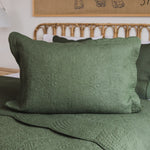 
                    
                      Funda de almohada verde con patrón quilted tradicional sobre cama-verde
                    
                  