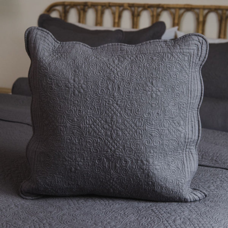 Funda de almohada gris con diseño quilted y bordes ondulados en sofá-gris claro