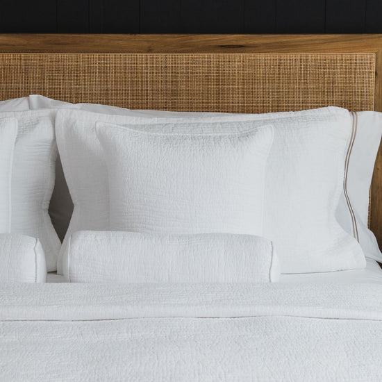 Funda de almohada blanca Girona con detalle de costura en cama-blanco