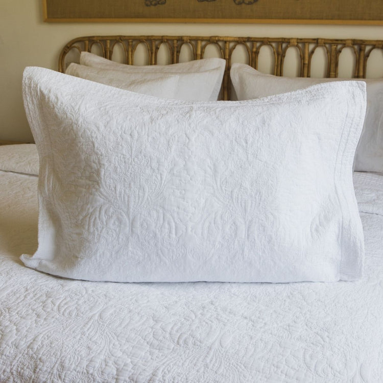 Funda de almohada blanca acolchada con patrón damasco en cama-blanco