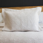 
                    
                      Funda de almohada Amalfi beige con patrón quilted sobre cama-beige
                    
                  