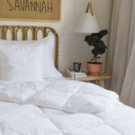 
                    
                      Cama con edredón blanco sintético, almohada y lámpara en dormitorio-blanco
                    
                  
