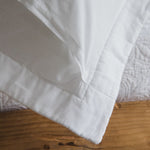 
                    
                      Funda de almohada blanca Amalfi doblada sobre superficie de madera-blanco
                    
                  