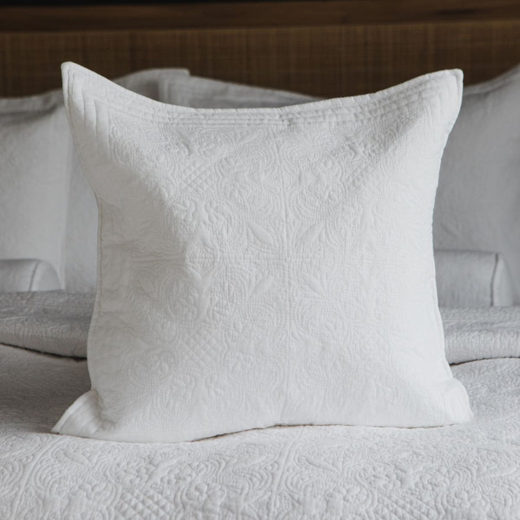 Funda de almohada blanca Amalfi con textura acolchada sobre cama-blanco