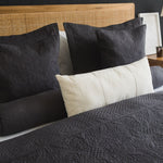 
                    
                      Almohada gris Amalfi decorativa en cama con headboard de ratán natural-gris
                    
                  
