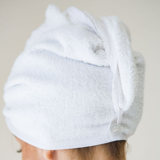 Turbante blanco de toalla absorbente envuelto alrededor de la cabeza-blanco