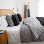 
                    
                      Cama con cubrecama gris, almohadas y textiles de lana natural-gris
                    
                  